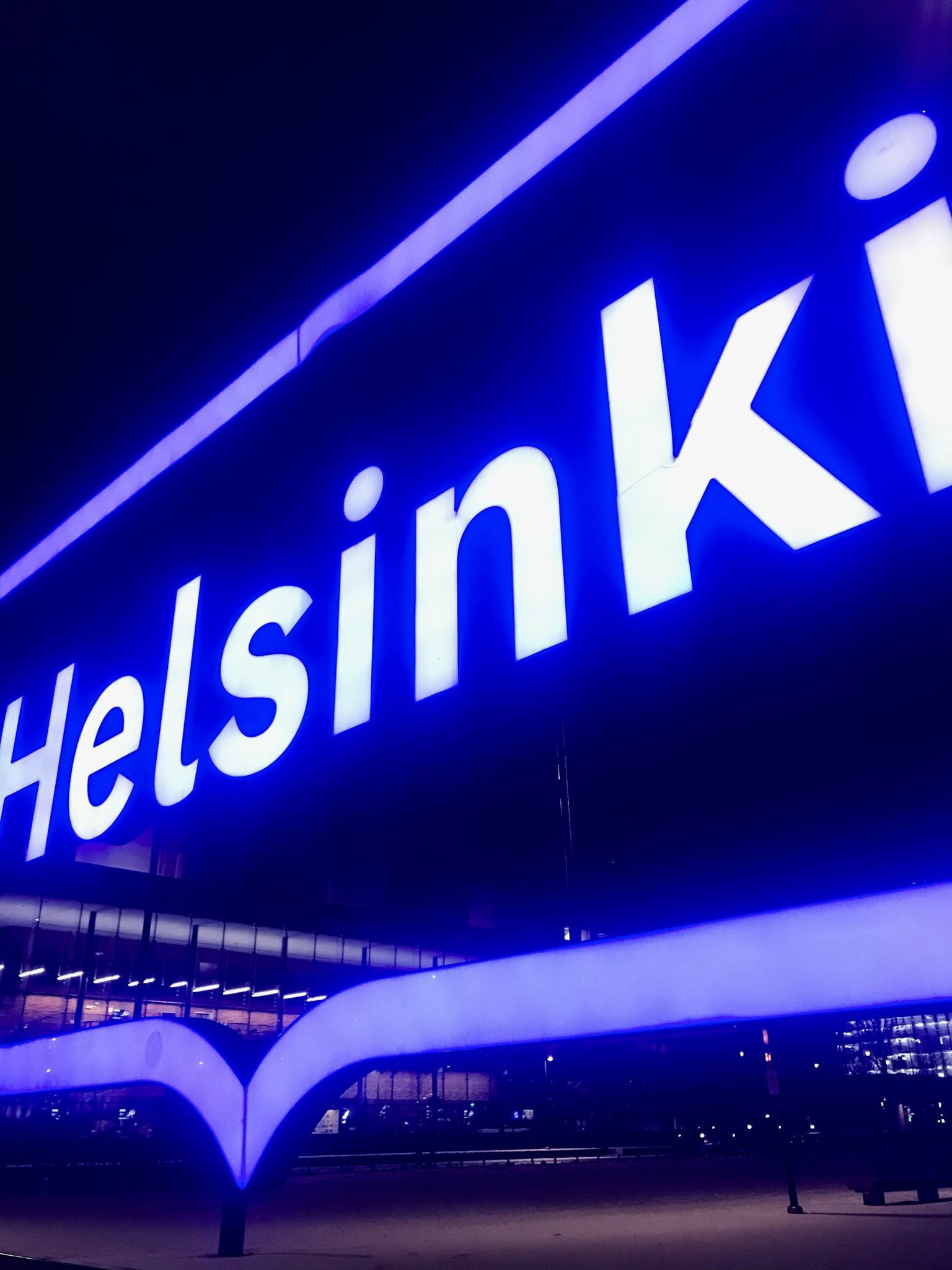 photograph of bright-blue glowing Helsinki neon signage